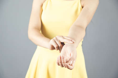 woman hand in pulse on gray backgroundの写真素材