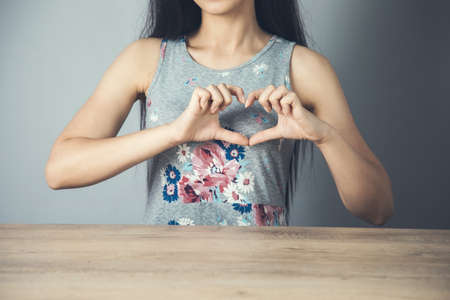 woman hand heart sign on the gray backgroundの写真素材