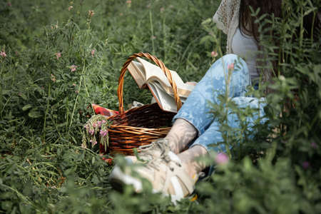 woman reading book sitting in the gardenの写真素材