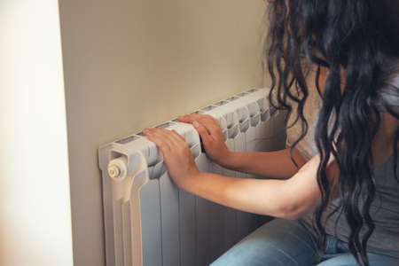 Woman hands warm on Home central heating systemの写真素材