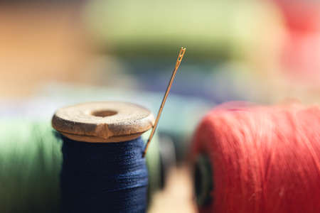 needle threaded thread on the wooden tableの写真素材