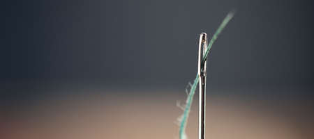 needle threaded thread on the wooden tableの写真素材