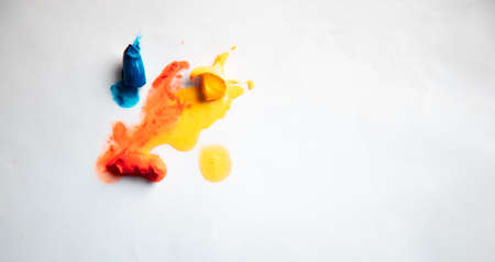 orange and yellow with blue oil paint on white backgroundの写真素材