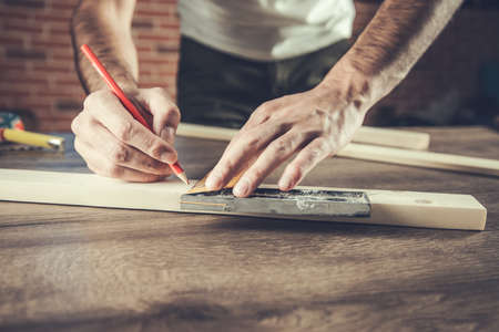the man carpenter measures the wooden boardの写真素材