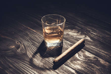 Whiskey and cigar on wooden background close upの写真素材