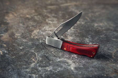 the pocket knife on the stone backgroundの写真素材