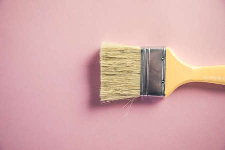 yellow paint brush and pastel pink backgroundの写真素材