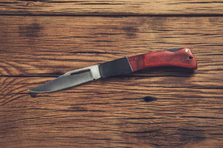 pocket knife on the wooden table backgroundの写真素材
