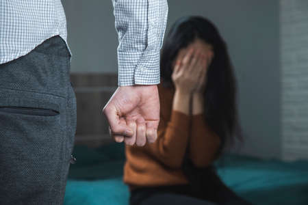 aggressive man beating woman in roomの写真素材