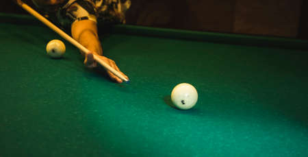 The young man playing billiards in club