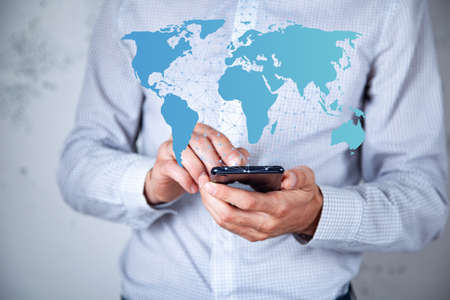 man holding phone and world map in screen