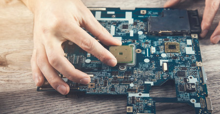 Engineer plugging CPU microprocessor to motherboard socketの写真素材