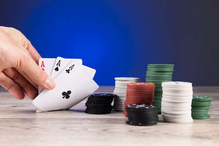 man playing poker and looking at aces on tableの写真素材