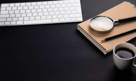 computer with notepad and coffee on office black table