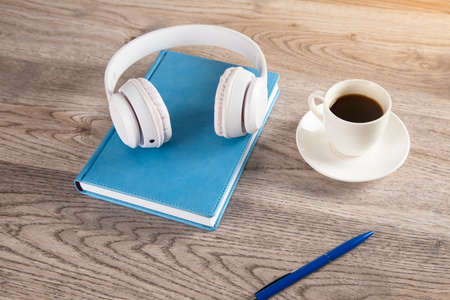 earphone on book with coffee on wooden tableの写真素材