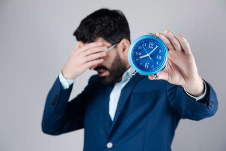 the sad business man holding clockの写真素材