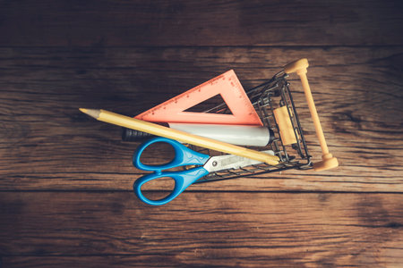 stationary on the shopping basket on wooden background