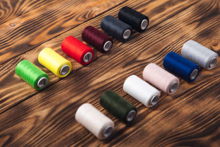 colorful thread spools on the wooden background.の写真素材