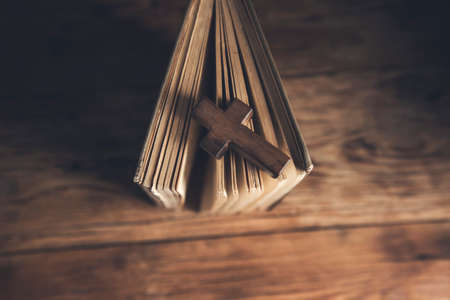 wooden cross on Holy Bible on wooden backgroundの写真素材