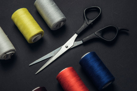 Colorful sewing threads and scissors on the black backgroundの写真素材