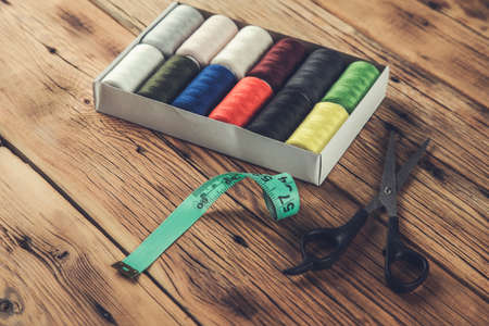 colored thread coils with scissors and meters on the tableの写真素材