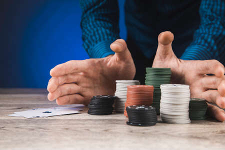 man playing poker and looking at aces on table