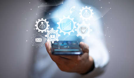 man holding phone with gear icons in screen