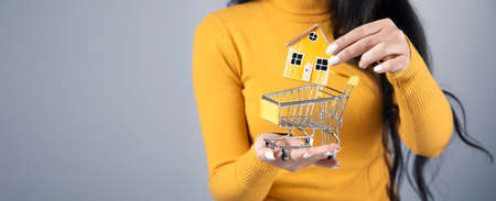 woman holding house model on the basket