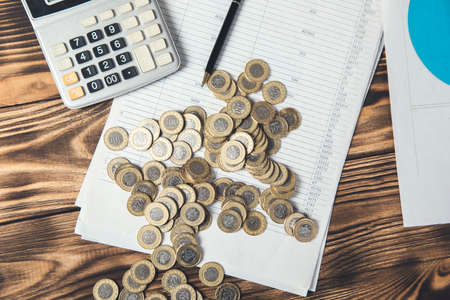 coins and calculator on document on tableの写真素材