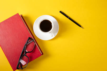 glasses on book with cup of coffeeの写真素材