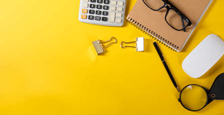 calculator with notebook and computer mouse and magnifier on table