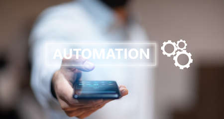 business man holding phone with automation text in screenの写真素材