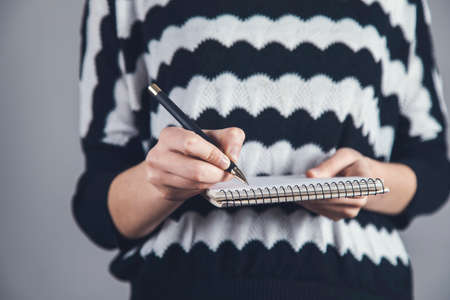 young woman holding pen and notebookの写真素材