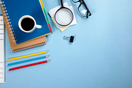 keyboard with notebook and pencils with coffee on working tableの写真素材