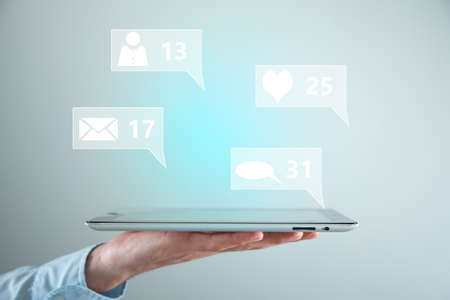 man holding tablet with social network icons in screen