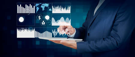 Businessman holding tablet with digital business graph