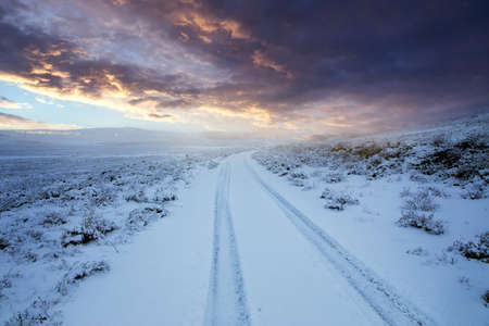 Snowy road in the winter at the sunset