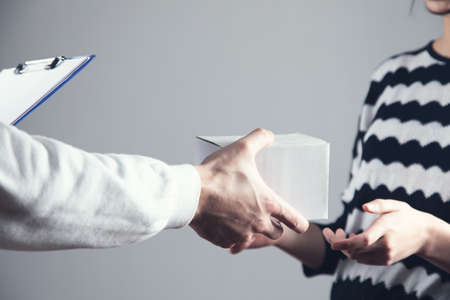 delivery man giving parcel box to recipientの写真素材