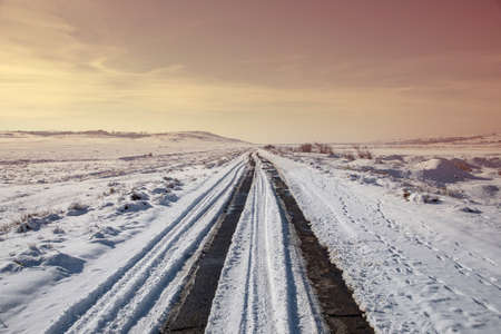 snowy road landscape at the sunsetの写真素材