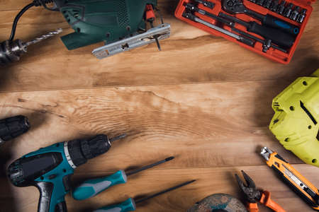 electric drill and architectural tools on wooden table