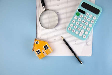 house model and calculator with magnifier on document on tableの写真素材