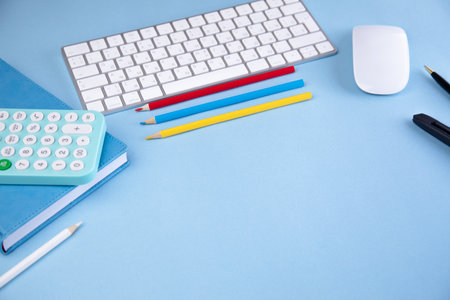 calculator on notebook with pencils and keyboard on the tableの写真素材