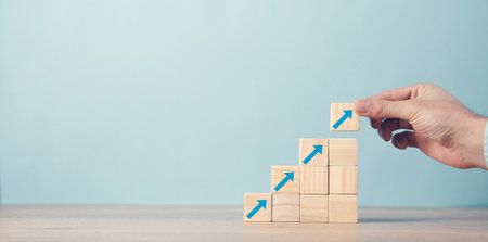Man hand arranging wood block stacking as step stair