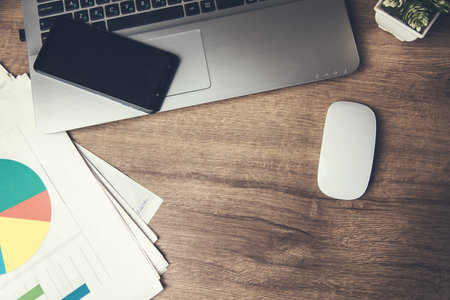 business concept. smartphone on computer laptop with graph on tableの写真素材