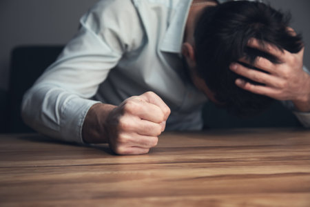 angry business man fists clenched on tableの写真素材