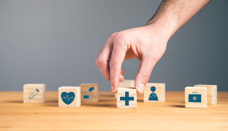 man holding wooden blocks with the health care medical symbolの写真素材