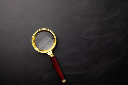 Magnifying glass over the chalkboard background.の写真素材