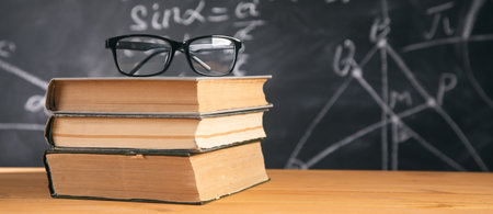 glasses on the book on chalkboard backgroundの写真素材