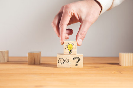 holding wooden cube with light bulb and idea