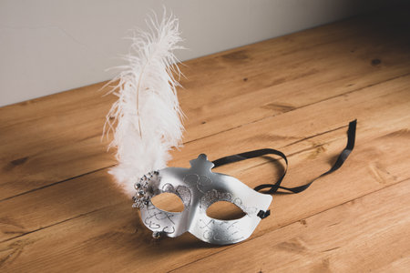 masquerade mask on a wooden table backgroundの写真素材
